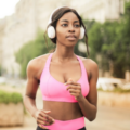 A woman with over the ear headphones and workout running.