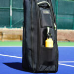 The Rocket tennis racuqet bag pictured on a tennis court.